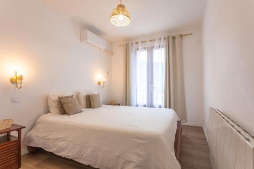 a bedroom with a white bed and a window at Charmante Villa Necsilia in Solliès-Toucas