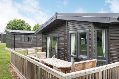 a wooden cabin with a wooden table and chairs at Best Western Plus Kenwick Park Hotel in Louth