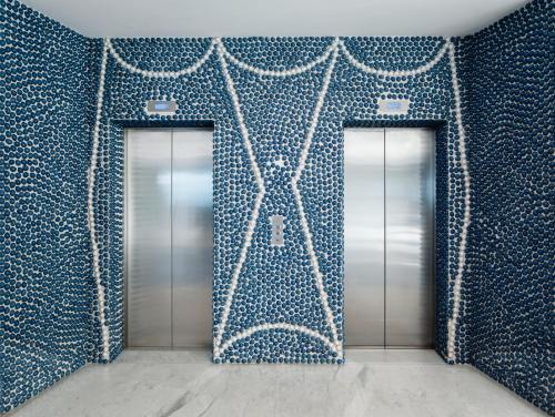 two elevators in a building with blue and white tiles at Parco dei Principi in Sorrento
