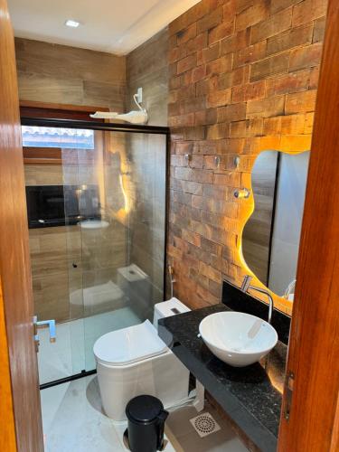 a bathroom with a white toilet and a sink at Casa Verde Jade in Areia