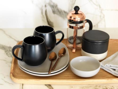 a wooden tray with two coffee cups and spoons at Hotel Palisade in Sydney