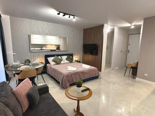 a bedroom with a bed and a living room at Sun Towers - Apartamenty Bryza - Apartamenty z parkingiem in Świnoujście