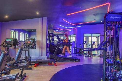 a woman is on a treadmill in a gym at Forest Pines Hotel, Spa & Golf Resort in Scunthorpe