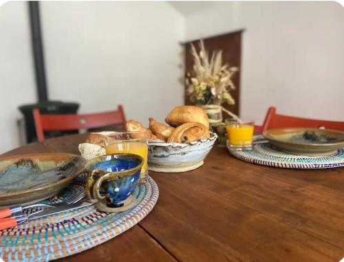 - une table en bois avec des assiettes de nourriture et de boissons dans l'établissement La maison aux volets bleus, à Caunes-Minervois