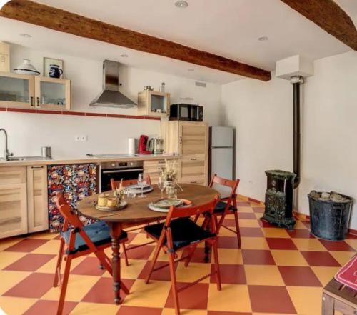 une cuisine avec une table et des chaises dans une pièce dans l'établissement La maison aux volets bleus, à Caunes-Minervois