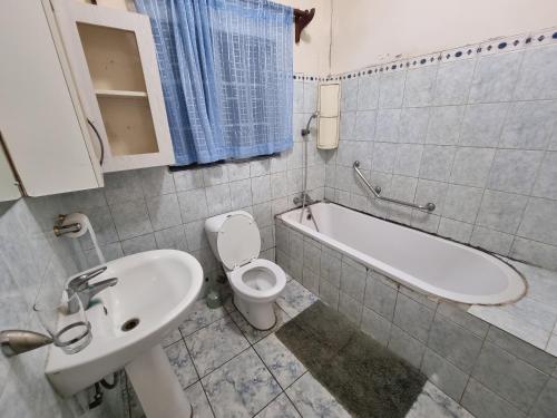 Un baño con lavabo, inodoro y bañera. en The Leafy Haven, en Harare