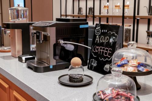 a kitchen counter with a coffee maker and twoason jars at Zhangjiajie Homeinn Plus Hotel in Zhangjiajie