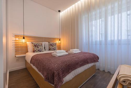a bedroom with a bed with towels on it at New Apartment by the Metro - 1E in Lisbon