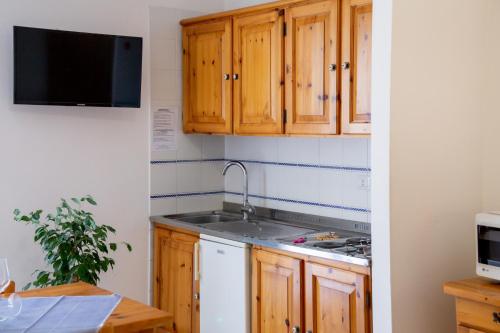 a kitchen with wooden cabinets and a sink at Gardenia Casa Vacanze in Alghero