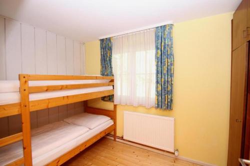 a bedroom with two bunk beds and a window at Appartements Reiterhaus in Wagrain