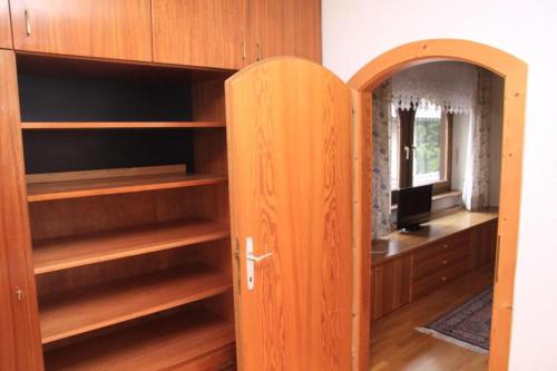 a closet with wooden shelves and a door at Appartements Reiterhaus in Wagrain