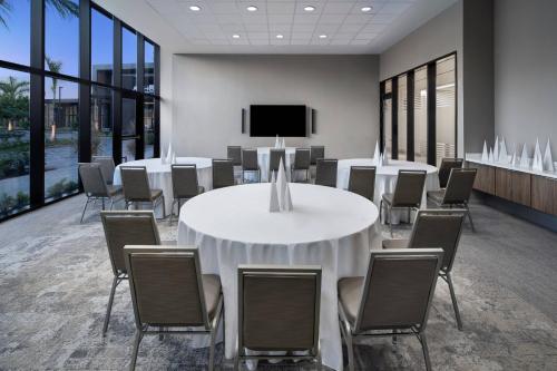 a conference room with tables and chairs and a tv at AC Hotel by Marriott Kingston, Jamaica in Kingston