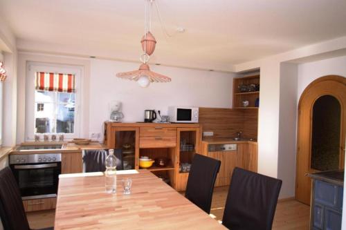 a kitchen with a wooden table and a dining room at Appartements Reiterhaus in Wagrain