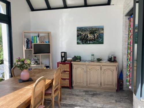 une salle à manger avec une table et une télévision dans l'établissement L'écrin de l'Océan, 80 mètres de la mer., au Pouliguen