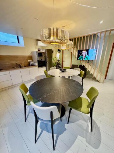 a dining room with a black table and chairs at Gites Rausa in Modave