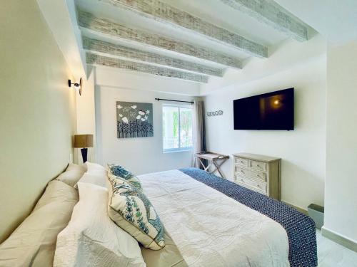 a bedroom with a bed and a tv on the wall at Bay Point- Ocean View Apartments by NIDHO PROPERTIES in San Andrés