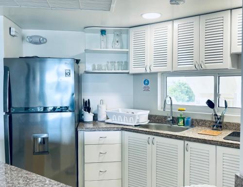 a kitchen with a stainless steel refrigerator and a sink at Bay Point- Ocean View Apartments by NIDHO PROPERTIES in San Andrés