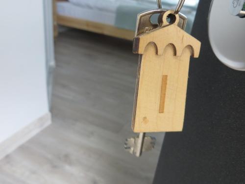 a wooden tag on a door with a house on it at Guesthouse Bacha & Lia in Mestia
