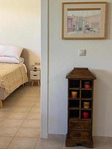 a bedroom with a bed and a table with a book shelf at Villa Zose' luz in Káto Ássos