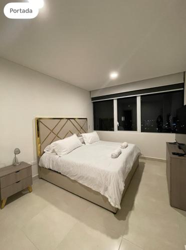 a bedroom with a large bed with two towels on it at Apartamento Nuevo y Lujoso! in Mexico City