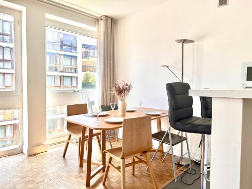 ジュヌヴィリエにあるChic Modern Studio Steps from Luxembourg Gardens Henri Barbusseのテーブルと椅子と窓のあるダイニングルーム