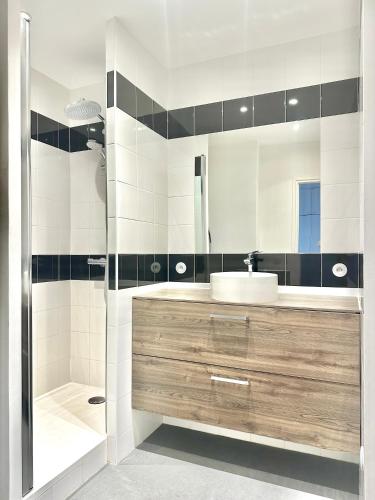 une salle de bain avec un lavabo et une douche dans l'établissement Chic Modern Studio Steps from Luxembourg Gardens Henri Barbusse, à Gennevilliers