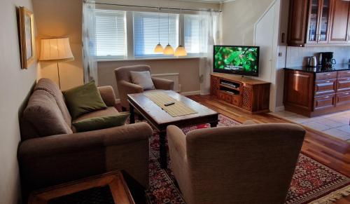 a living room with two couches and a tv at Tre rum och kök centralt in Västervik