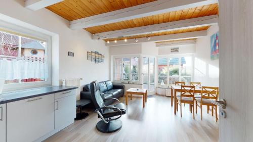 a kitchen and living room with a table and chairs at Ferienhaus kleiner Leuchtturm - Steuerbord Fehmarn Kopendorf - mit Garten und Terrasse in Fehmarn