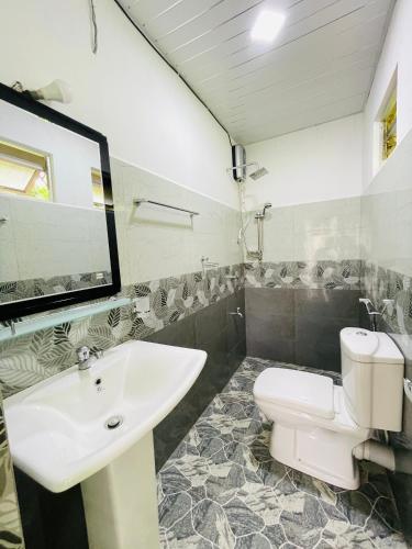 a bathroom with a white sink and a toilet at Paradise Villa in Weligama
