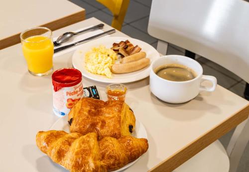 a table with two plates of food and a cup of coffee at B&B HOTEL Grenoble Université 1 in Gières