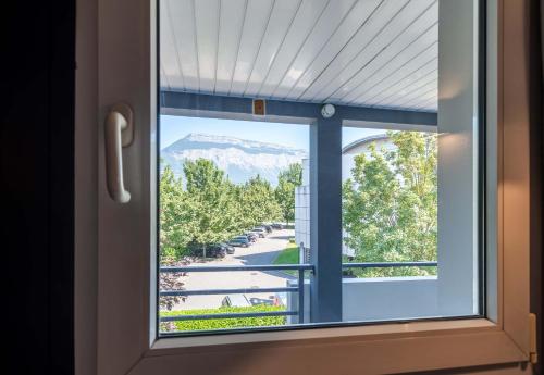 a window with a view of a mountain at B&B HOTEL Grenoble Université 1 in Gières