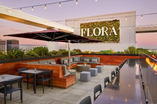 a rooftop bar with tables and chairs and a pool at AC Hotel by Marriott Los Angeles South Bay in Los Angeles