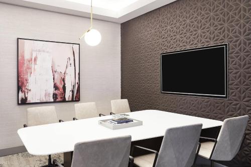 a conference room with a white table and chairs at AC Hotel by Marriott Los Angeles South Bay in Los Angeles