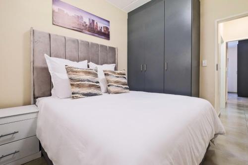 a bedroom with a large bed with white sheets and pillows at Ridge Comfort in Midrand
