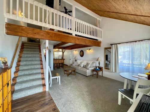 a living room with a staircase leading up to a loft at Sierra Mountain Lodge - Vacation Rentals - Yosemite in Ahwahnee