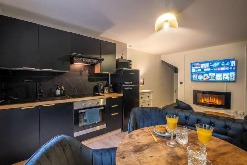 una cucina e un soggiorno con tavolo e sedie in legno di Le Boudoir Secret - Love Room avec Chambre Secrète a Le Luc