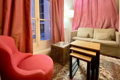 un salon avec une chaise rouge et un canapé dans l'établissement The Triplex - Cosy & Charming - Montorgueil, à Paris