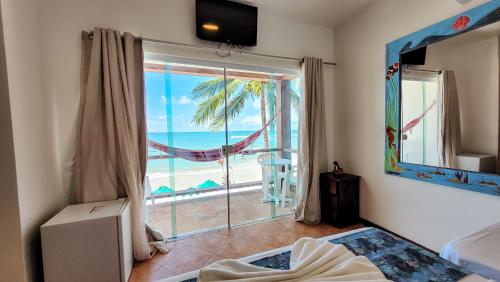 a bedroom with a window with a view of the ocean at Pousada Casa da Sogra in Morro de São Paulo