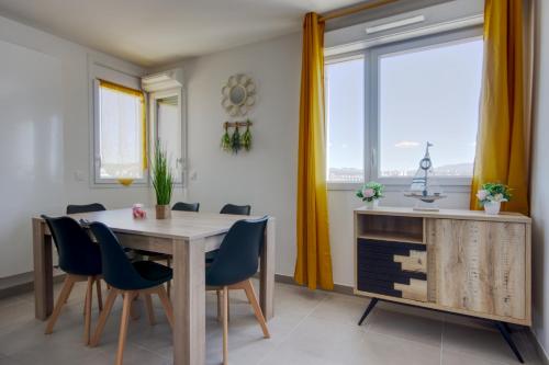 une salle à manger avec une table et des chaises et une fenêtre dans l'établissement T3 Duplex avec parking et balcon à Euromed, à Marseille