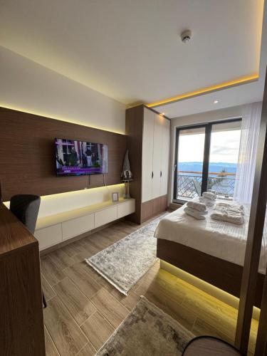 a bedroom with a large bed with a tv on the wall at Fashion Residence Hill in Kopaonik