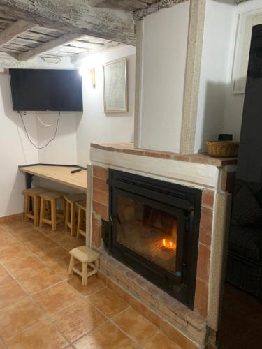 a living room with a fireplace and a table at Apartamento Turístico la Casa escondida in Casas del Monte