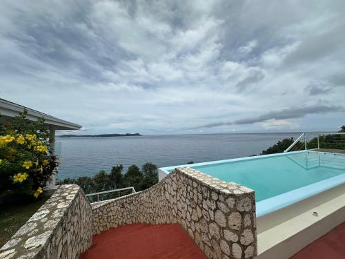 a swimming pool with a view of the water at Maha Villa - Sea View Island Retreat with private beach in Pinamihagan