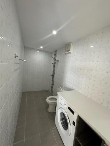 a bathroom with a toilet and a washing machine at Maha Villa - Sea View Island Retreat with private beach in Pinamihagan