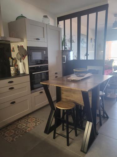 une cuisine avec une table en bois et quelques chaises dans l'établissement Appartement T2 vue sur les sanguinaires, à Ajaccio