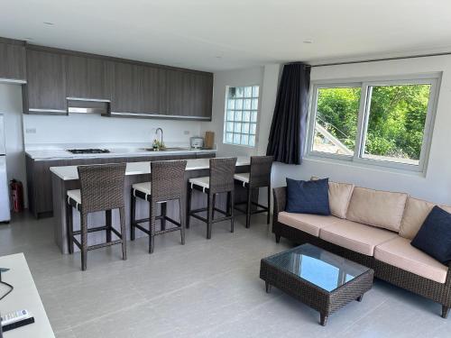 a kitchen and living room with a couch and a table at Maha Villa - Sea View Island Retreat with private beach in Pinamihagan
