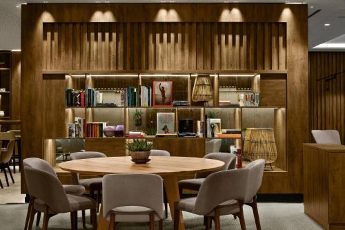 a dining room with a table and chairs and bookshelves at AC Hotel by Marriott Innsbruck in Innsbruck