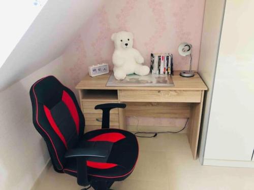 a chair and a teddy bear sitting at a desk at Villa 320m2 a 1h30 de Paris in Montcresson