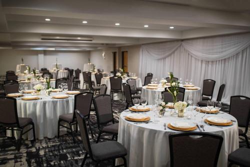 a banquet hall with white tables and chairs at Renaissance Minneapolis Bloomington Hotel in Bloomington