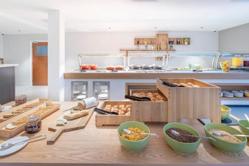 a kitchen with a table with boxes of food at Holiday Inn Bristol Airport by IHG in Redhill