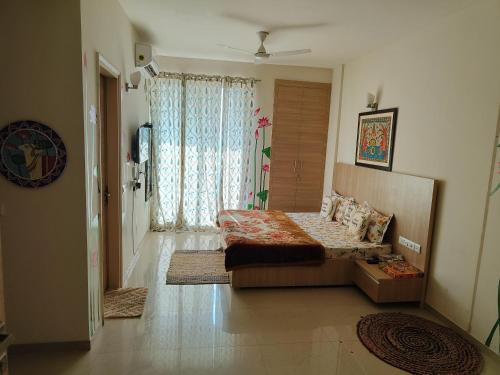 a bedroom with a bed and a large window at Vasudev Kutumb Atithi Devo Bava in Vrindāvan